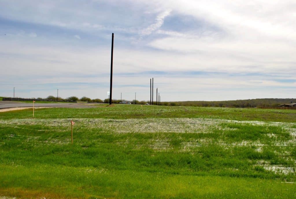 grassy field with black pole in the distance