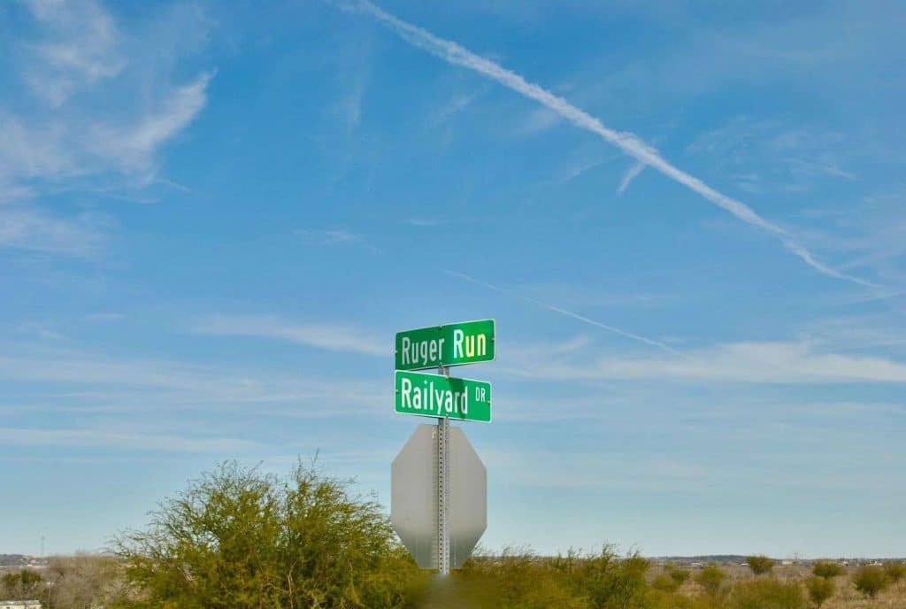 two green street signs on top of a stop sign