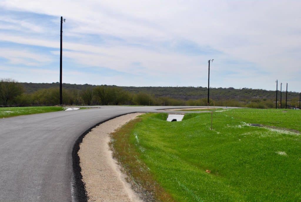 curved road in the middle of a green field