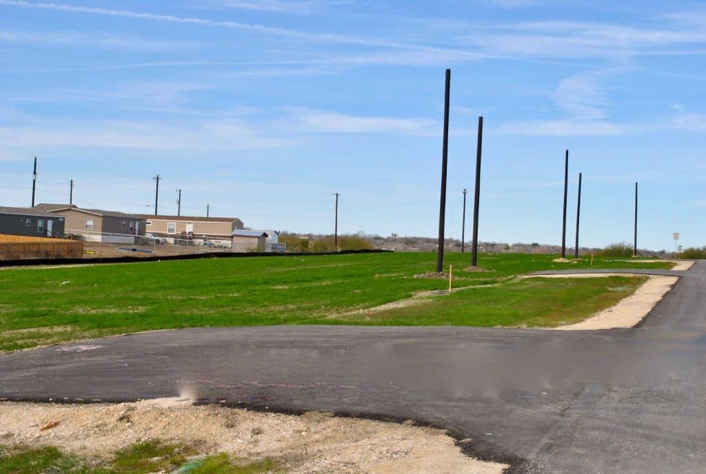 an empty road with a green field 2