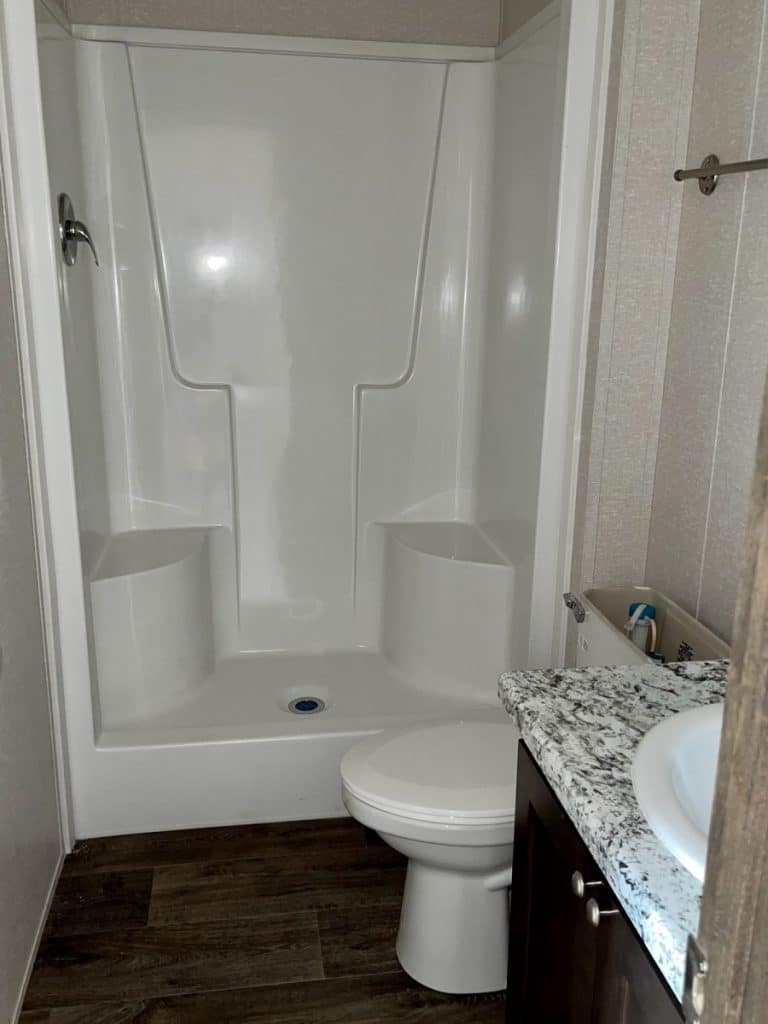 a white toilet next to a bath tub