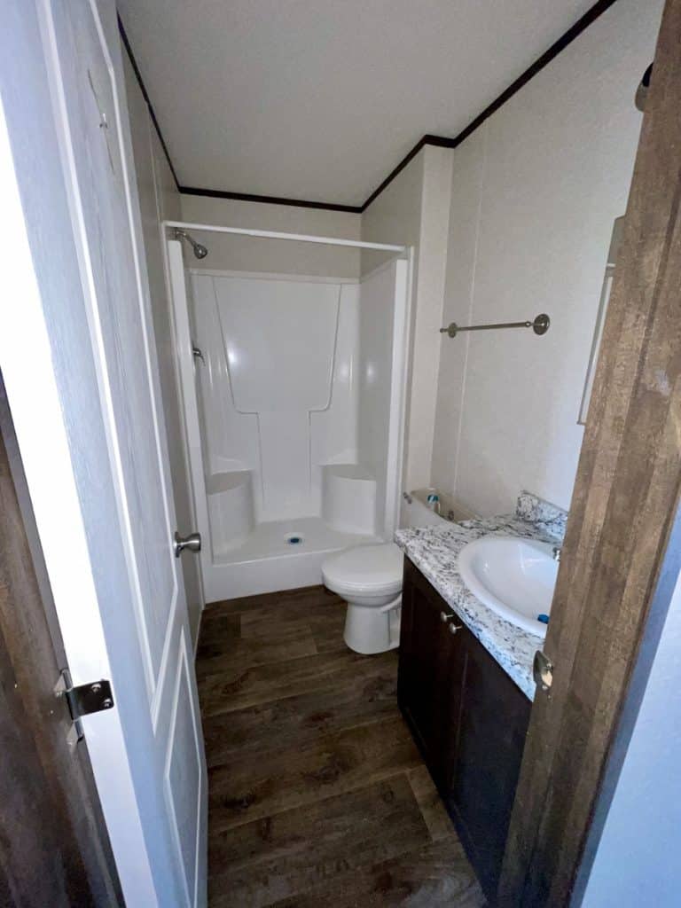 a bathroom with a toilet, sink, and shower