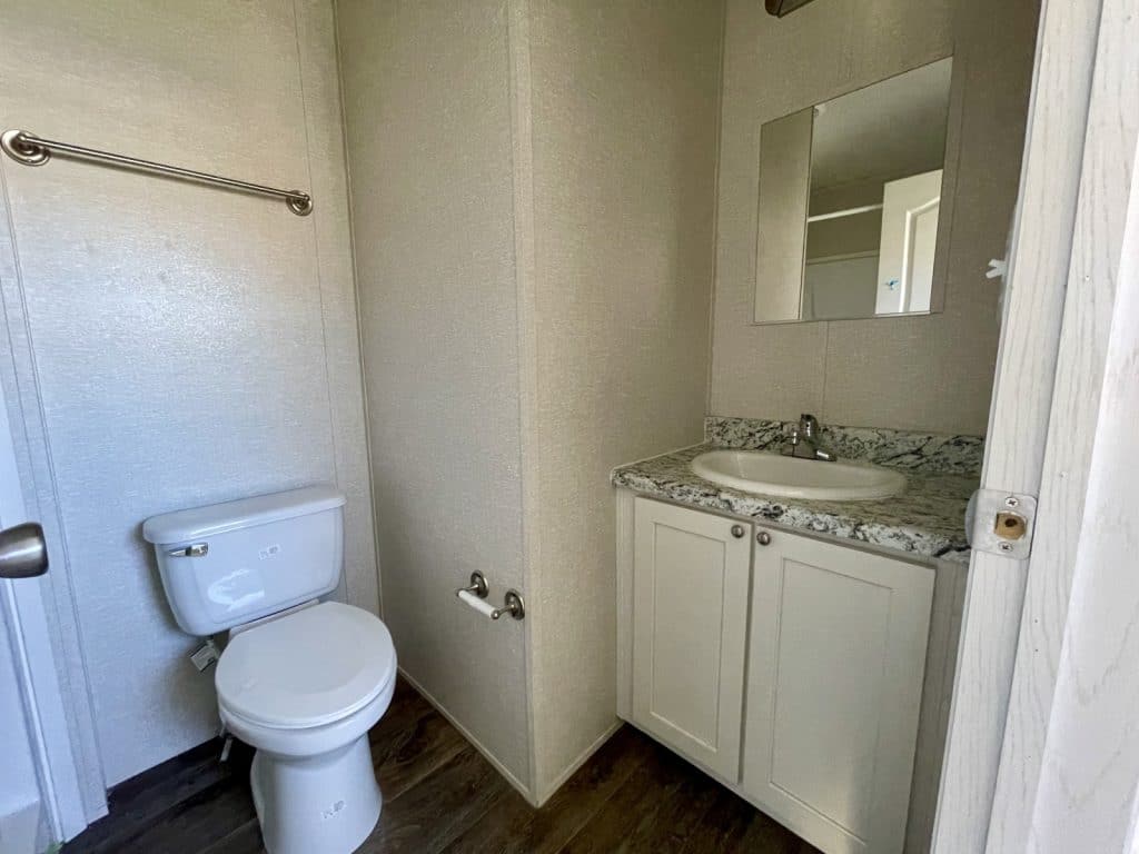 primary bathroom with white toilet and sink wide angle 2