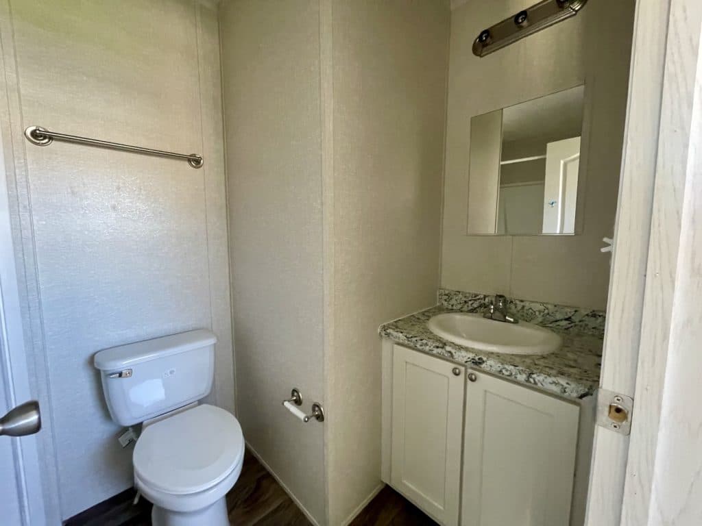 primary bathroom with white toilet and sink wide angle 1