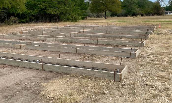 a row of wooden benches on top of a dirt field when building your new home design